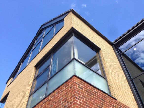 buff and red brick building with glass corner window