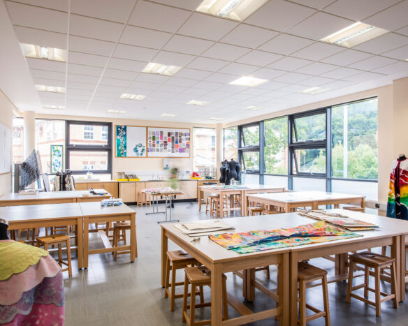 interior of school art classroom with tables and stools