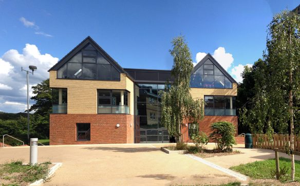 approach view of front entrance to building with red brick and double height windows