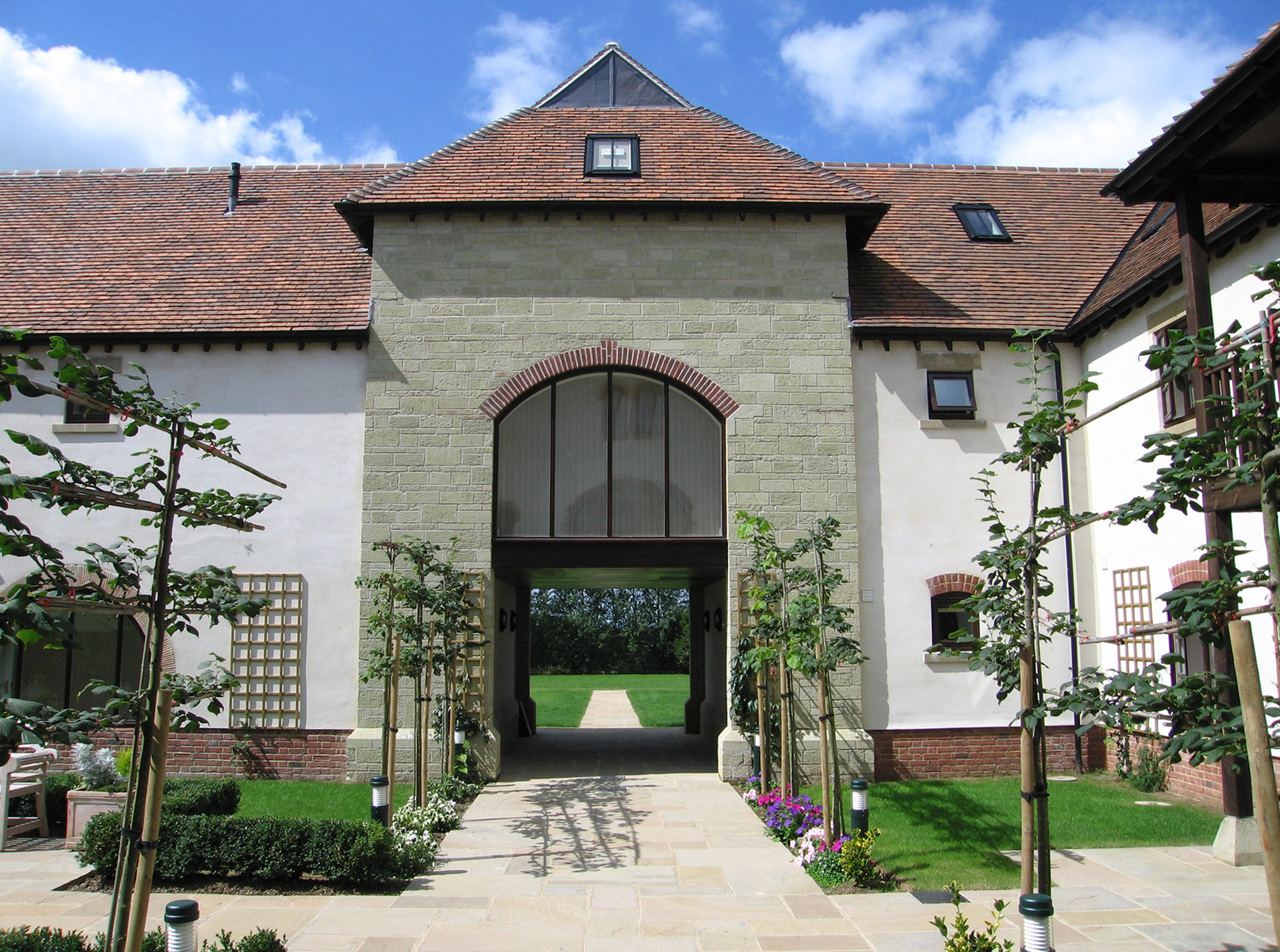 stone courtyard with walkway through to garden under arch window