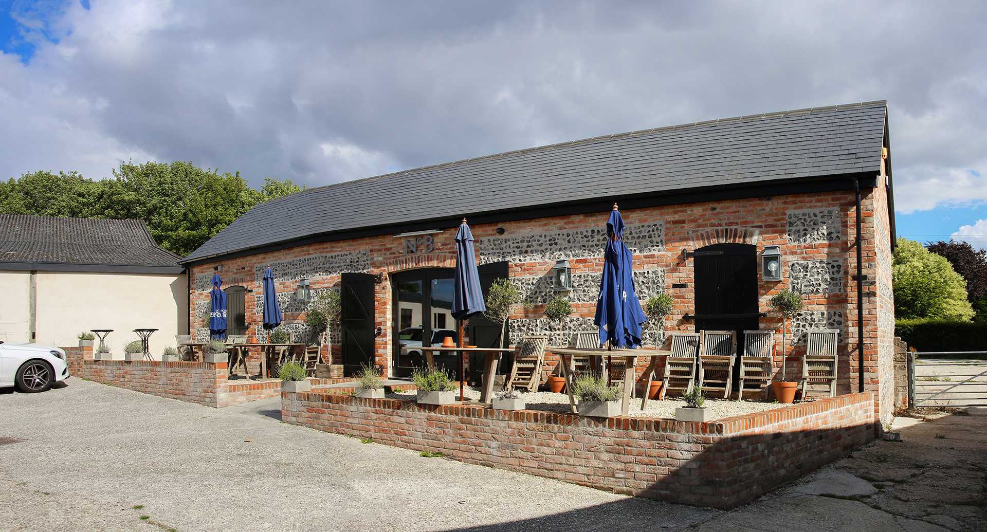 front view of finished red brick building with seating after in front