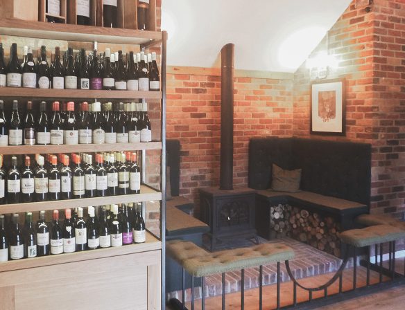 interior seating space in shop with log fire and exposed red brick