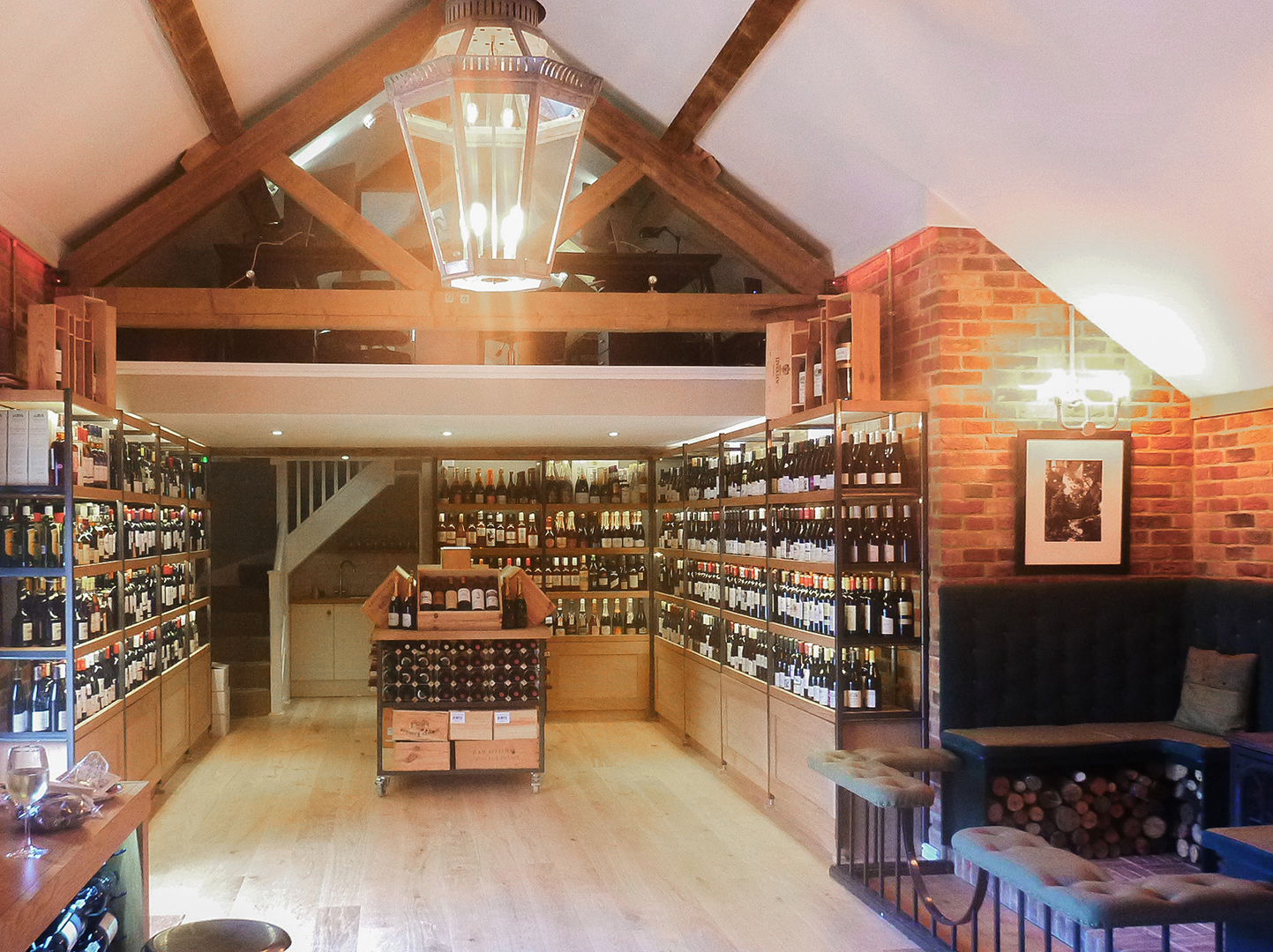 interior of wine shop with vaulted ceilings and dog legged stairs leading to an office on a mezzanine level