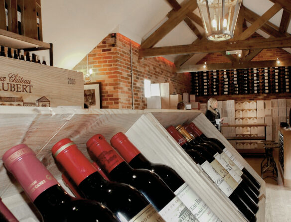 wine bottles on display inside a wine shop with vaulted ceilings and exposed beams