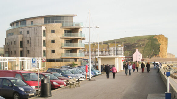 side view of west bay finished with carpark in front and cliff tops in distance