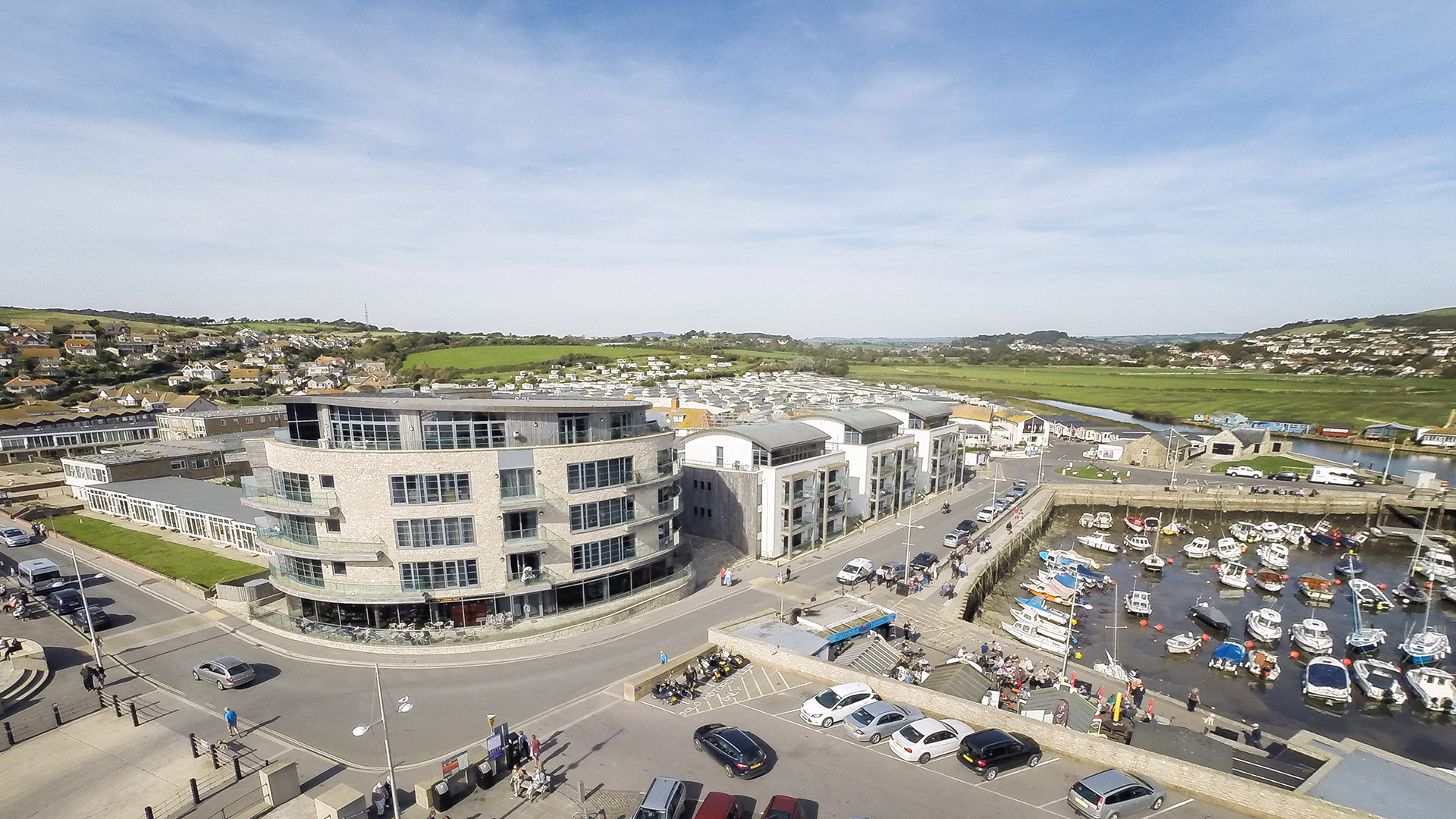 aerial view of west bay building with quay on right and car park in front