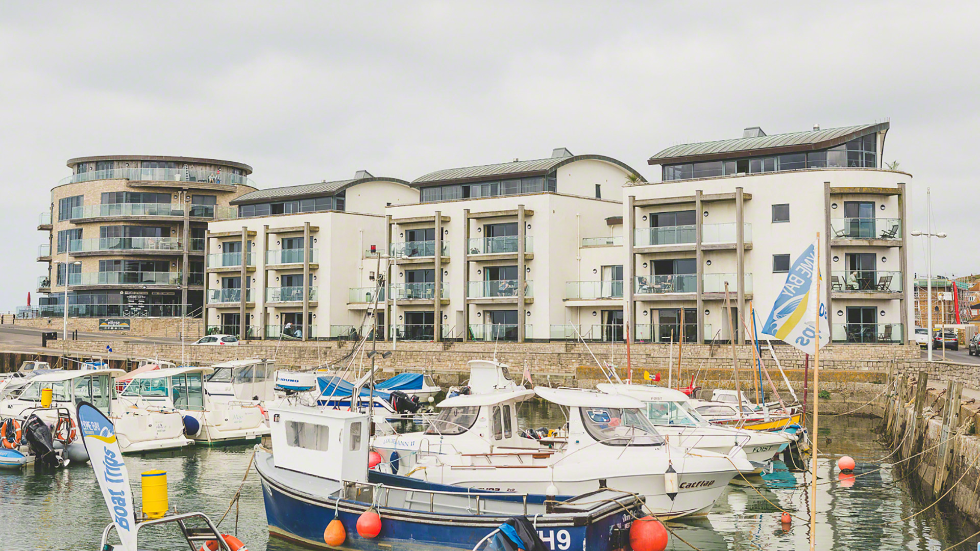 view of west bay apartments across the harbour with boats