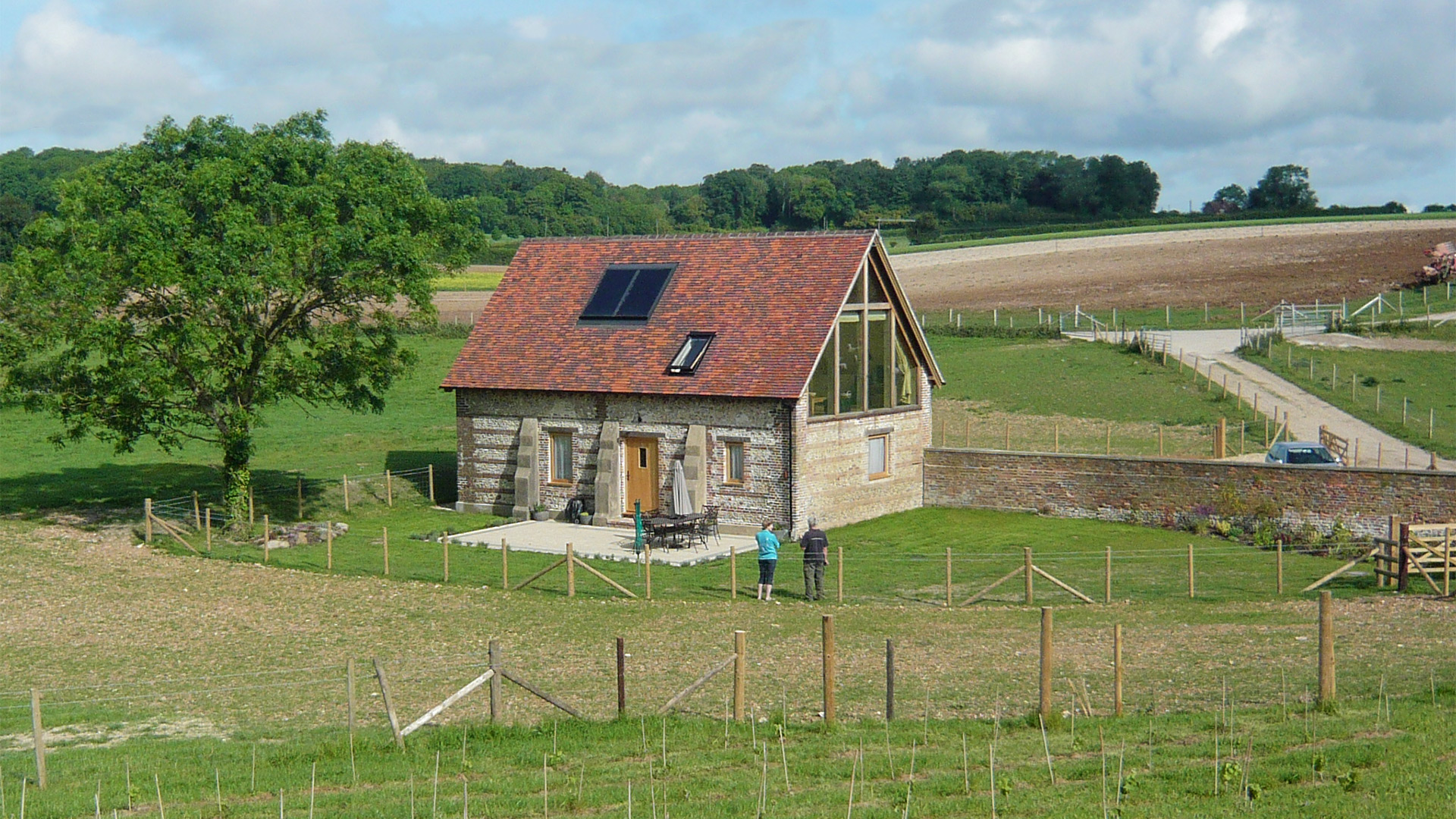 external rear view of red brick shepherds hut from field