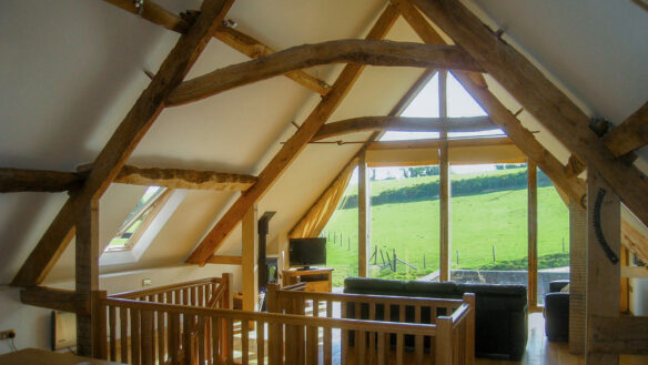 interior living room with beautiful across fields, large glass windows and exposed wooden beams