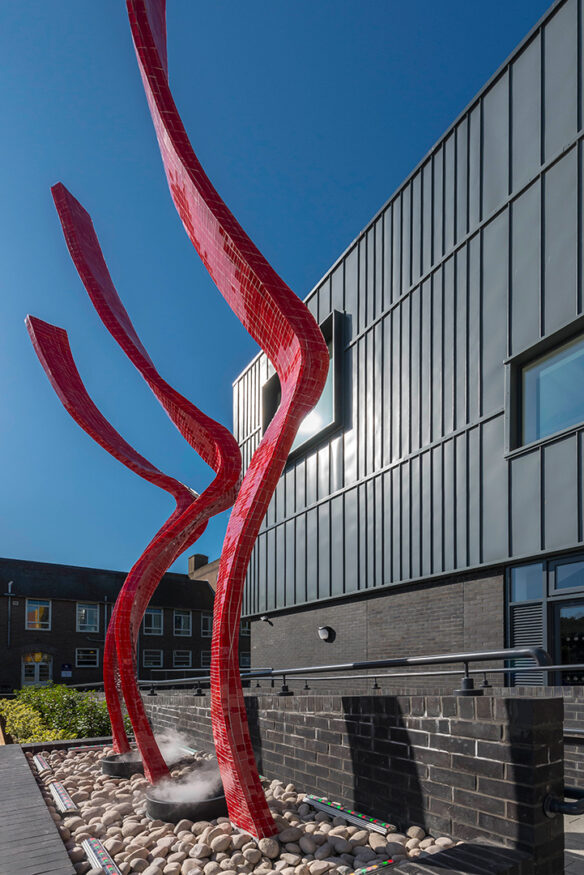 external red mosaic art structure in front of building