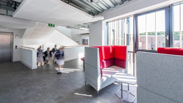 interior hallway seating area with lift and staircase in background