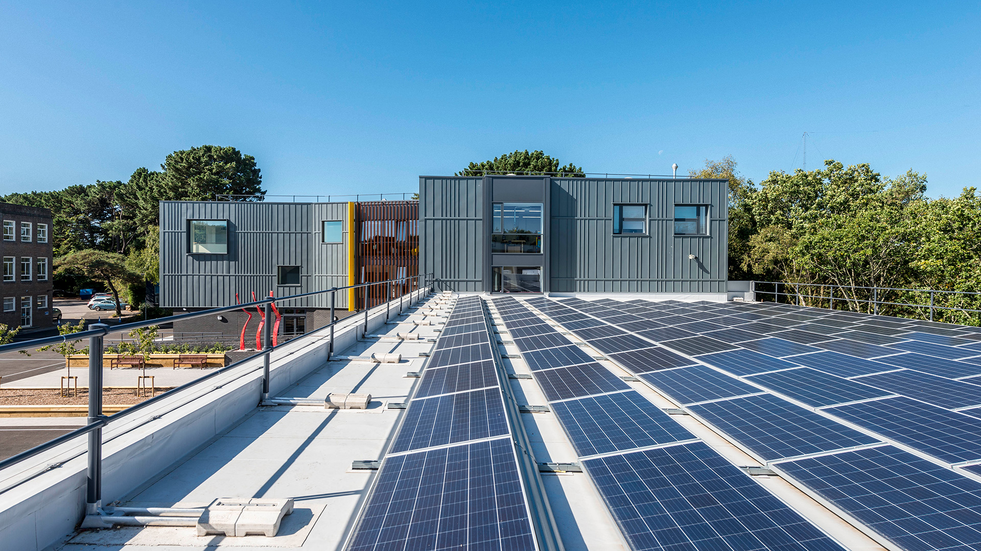 Solar panels on rooftop with school building in background