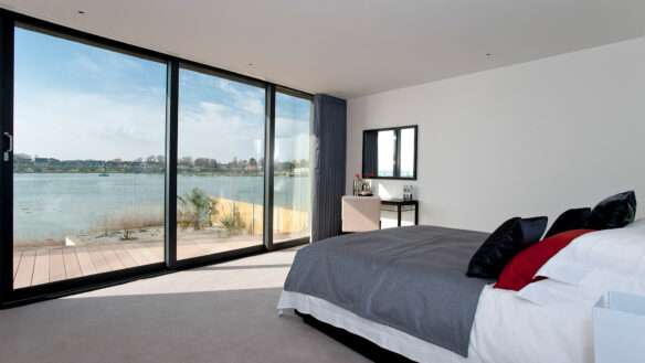 interior view of bedroom with minimalistic white decor and stunning views across the harbour