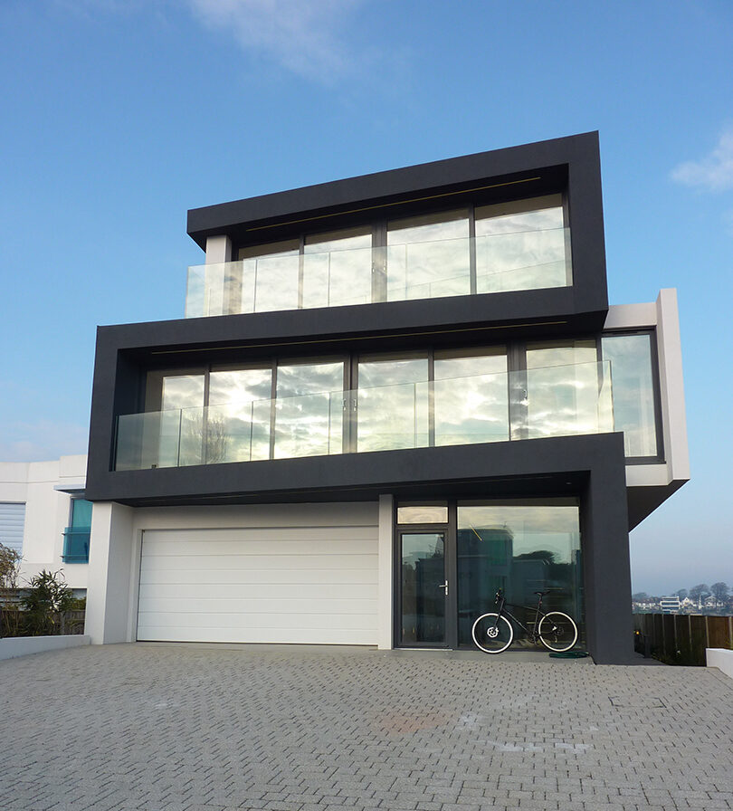 front view of zigzag house with driveway and garage