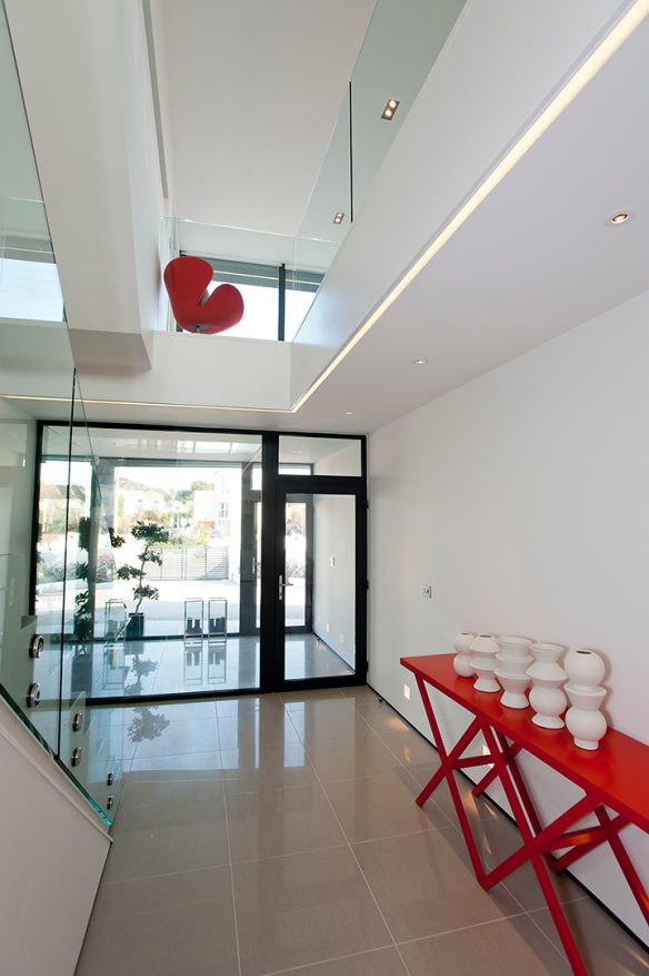 interior entrance view of contemporary house with red chair and table