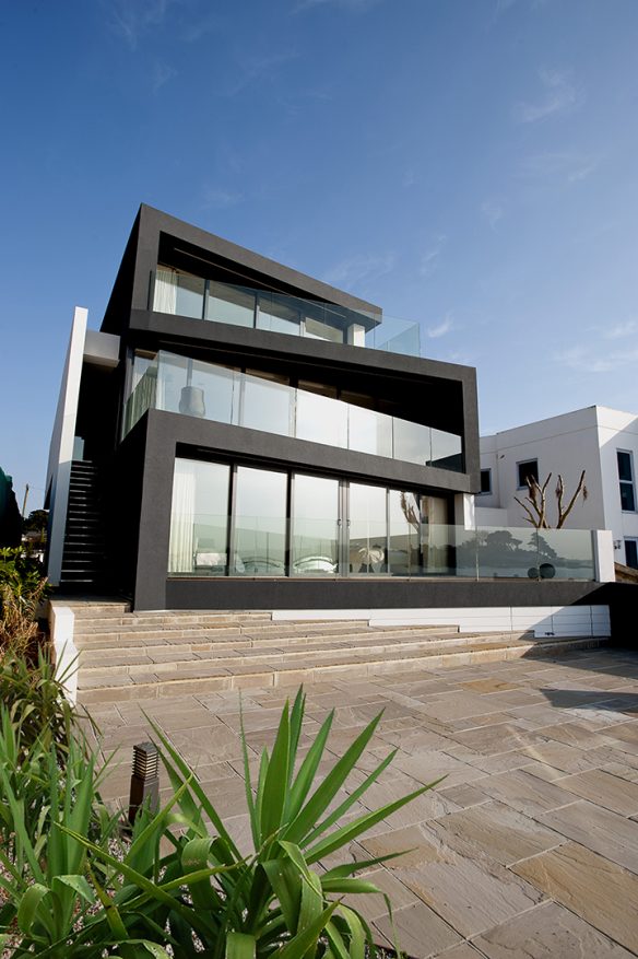 rear view of zigzag house with large windows and balconies on each floor