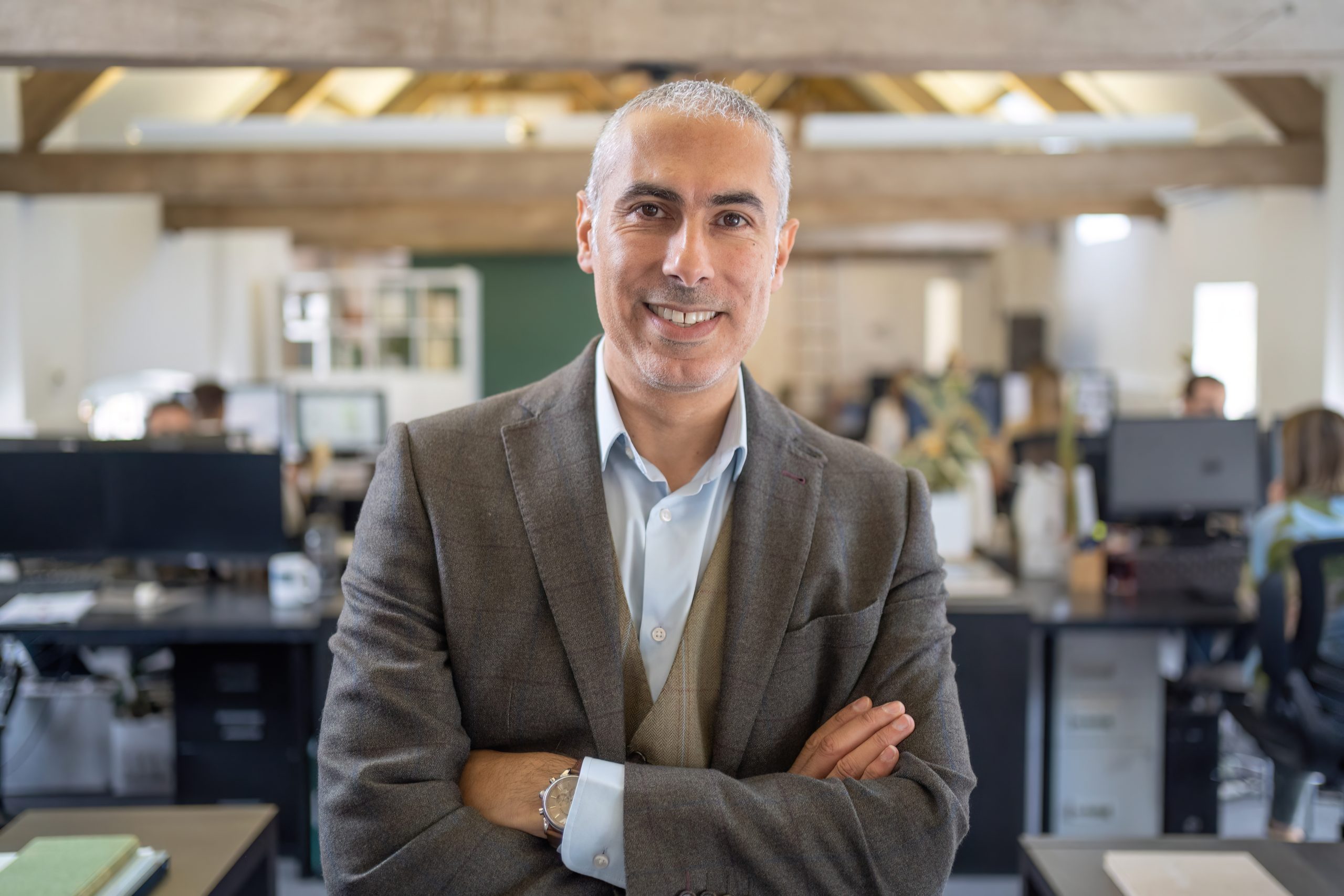 man smiling at camera with arms crossed