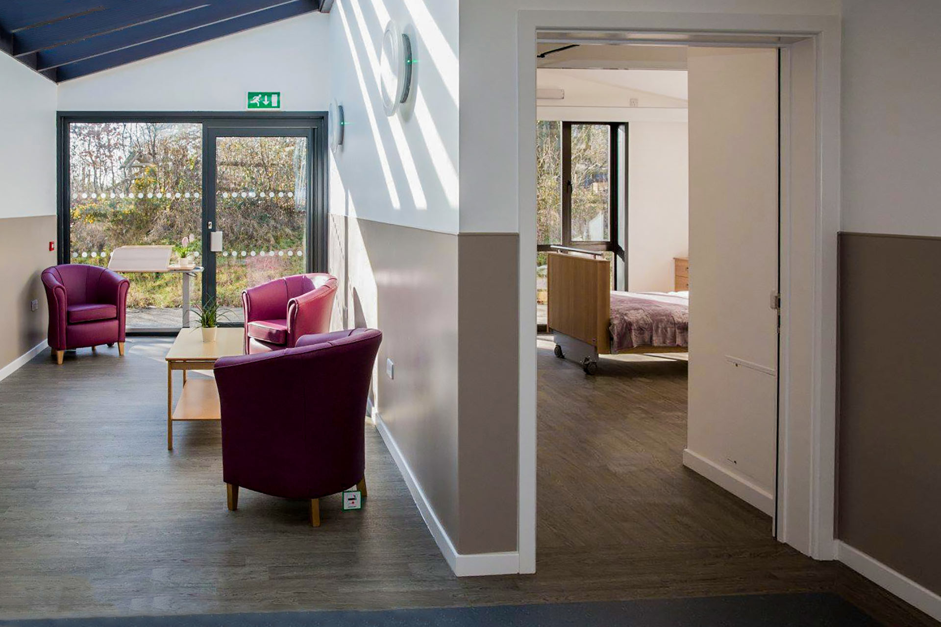 bedroom and seating area in neutral tones with slanting glass roof