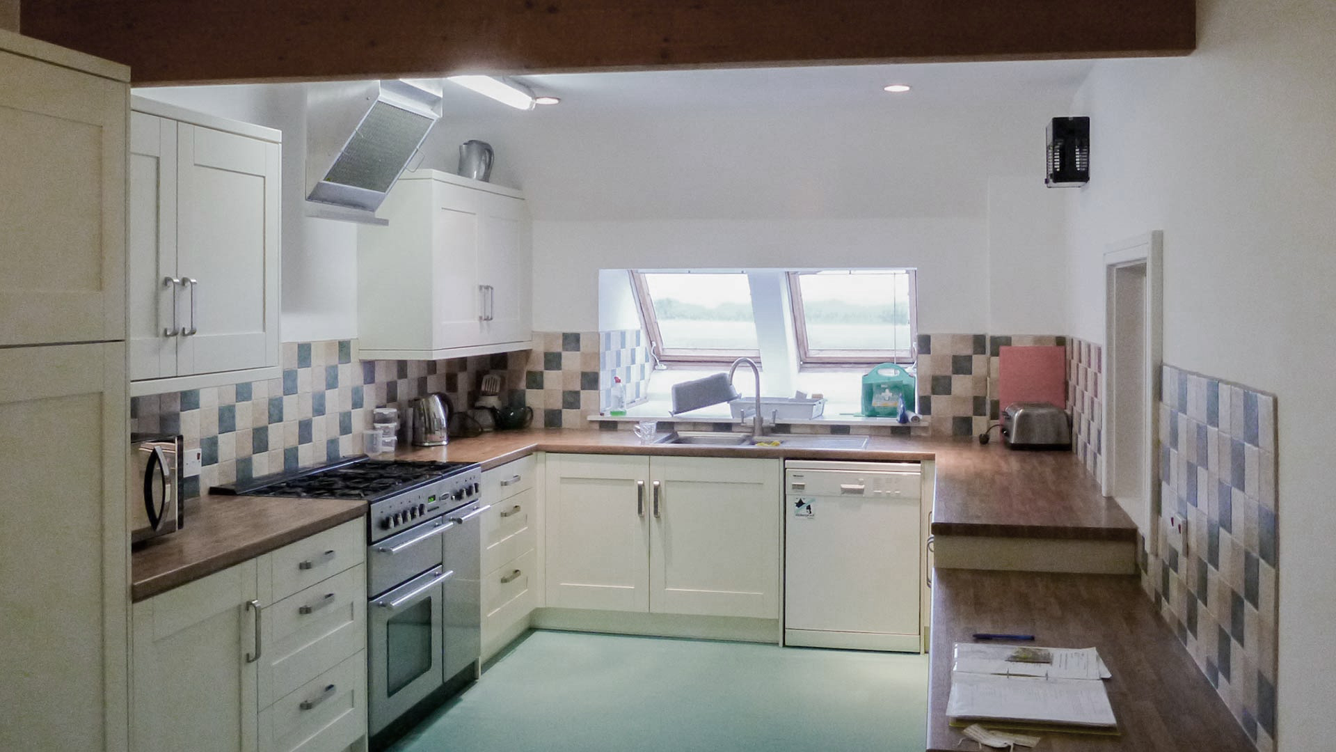 before kitchen area with sky lights and exposed wooden beam