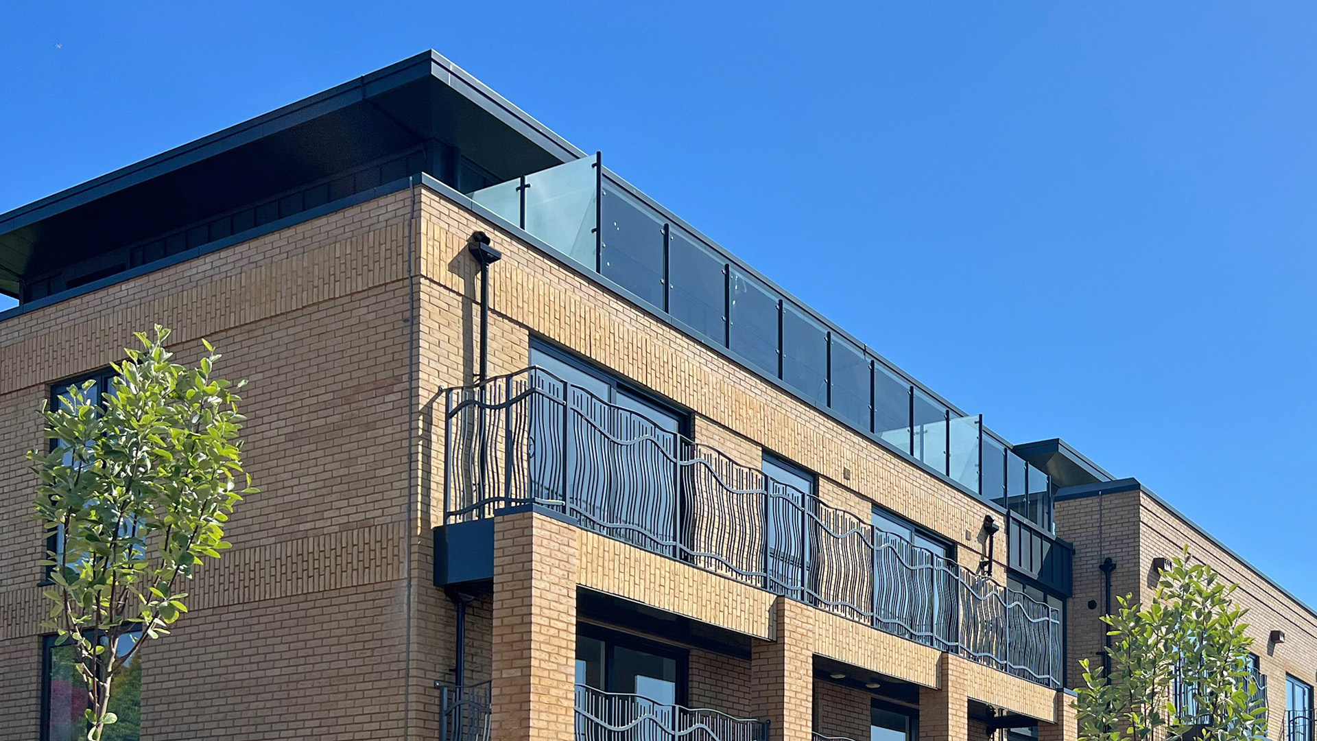details side view of top of new flats with balconies and glass balustrades