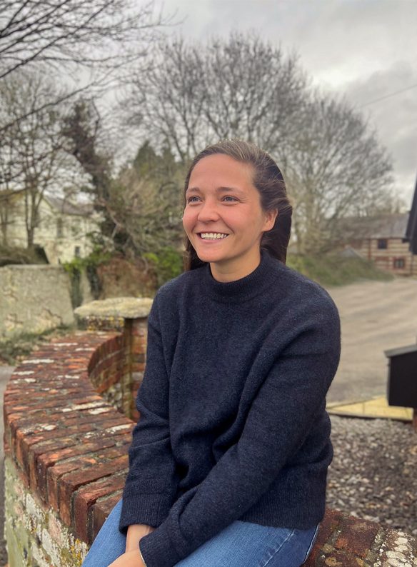 woman smiling sat on brick wall