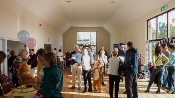 interior view of village hall with many people inside chatting