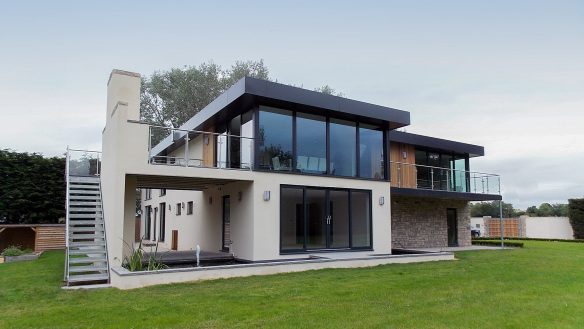 front view of beautiful modern house with stone and white walls and external staircase on left