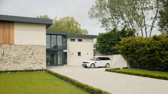 front view of large contemporary house with large glass entrance and flat roof