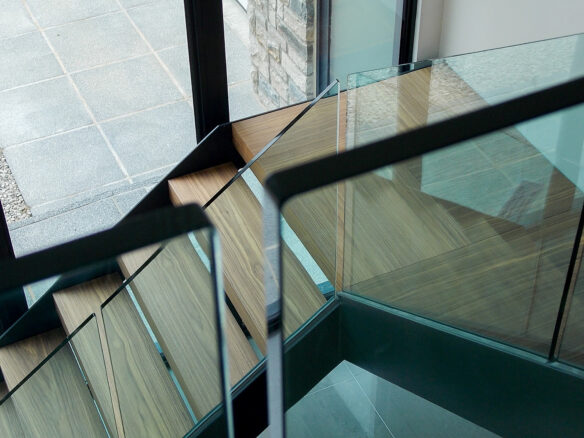 detailed view of modern dog legged stair case with glass balustrade