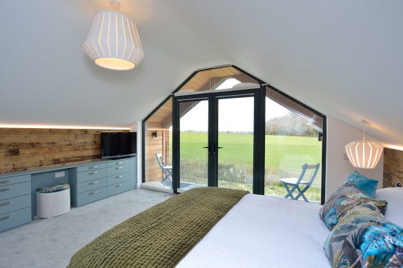 internal view of bedroom with balcony looking out to stunning country views