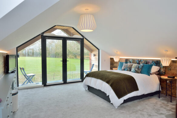 internal view of bedroom with balcony looking out to stunning country views