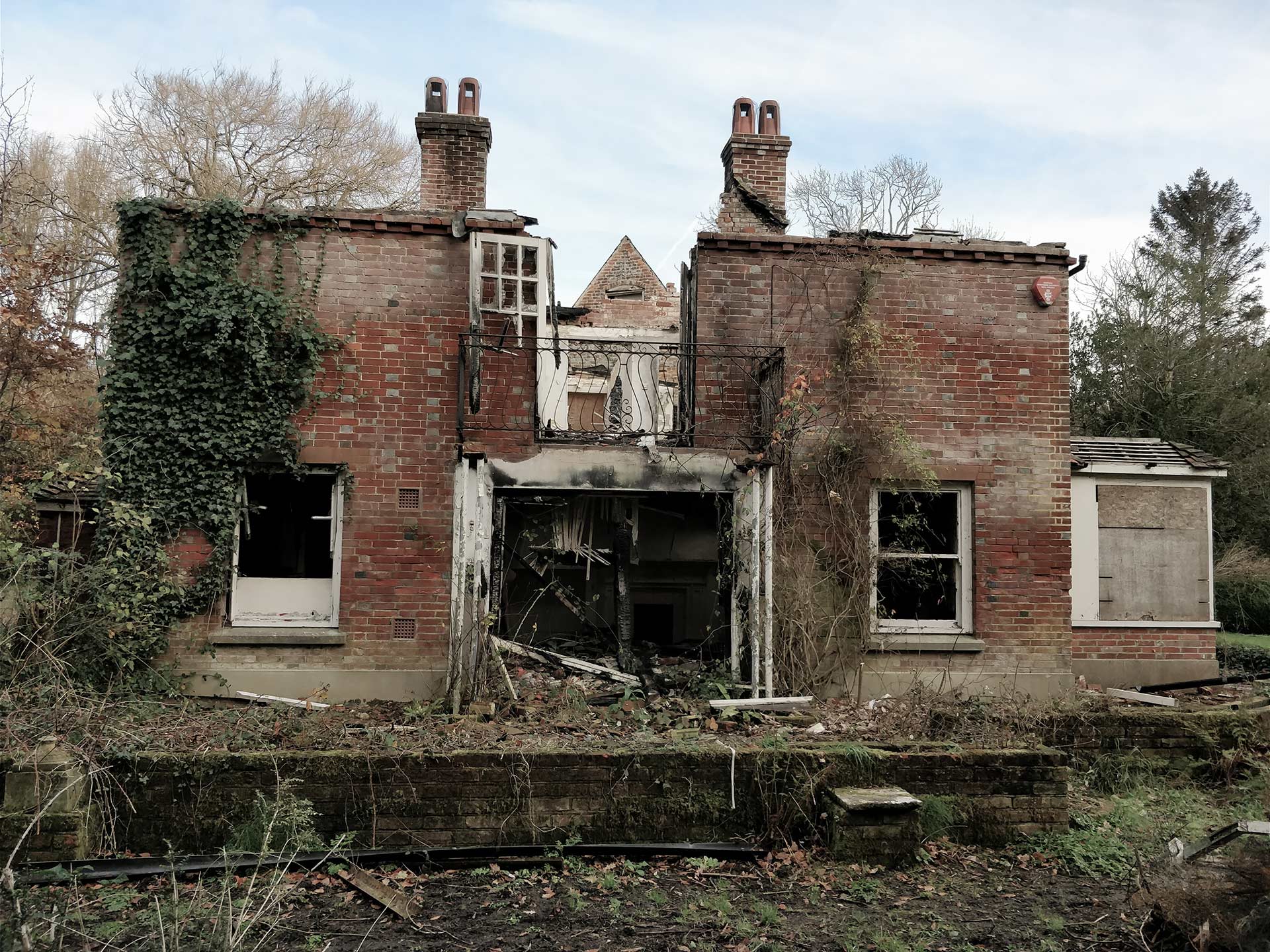existing before photo of dilapidated red brick building with roof collapsed and doors fallen down