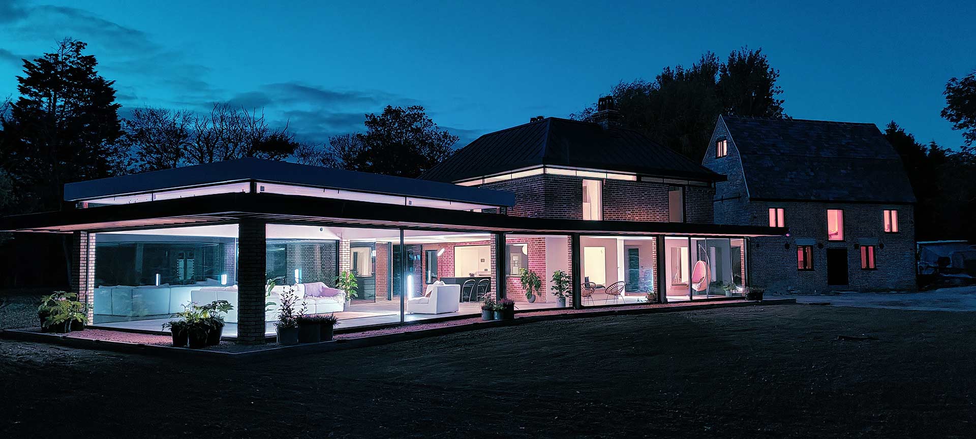 external rear view of beautiful house at night lit up