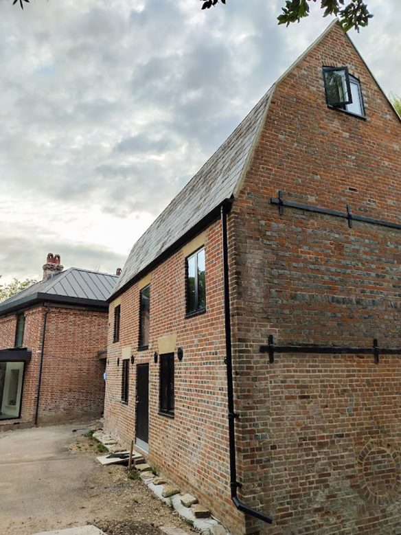 side view of traditional red brick house with black window details