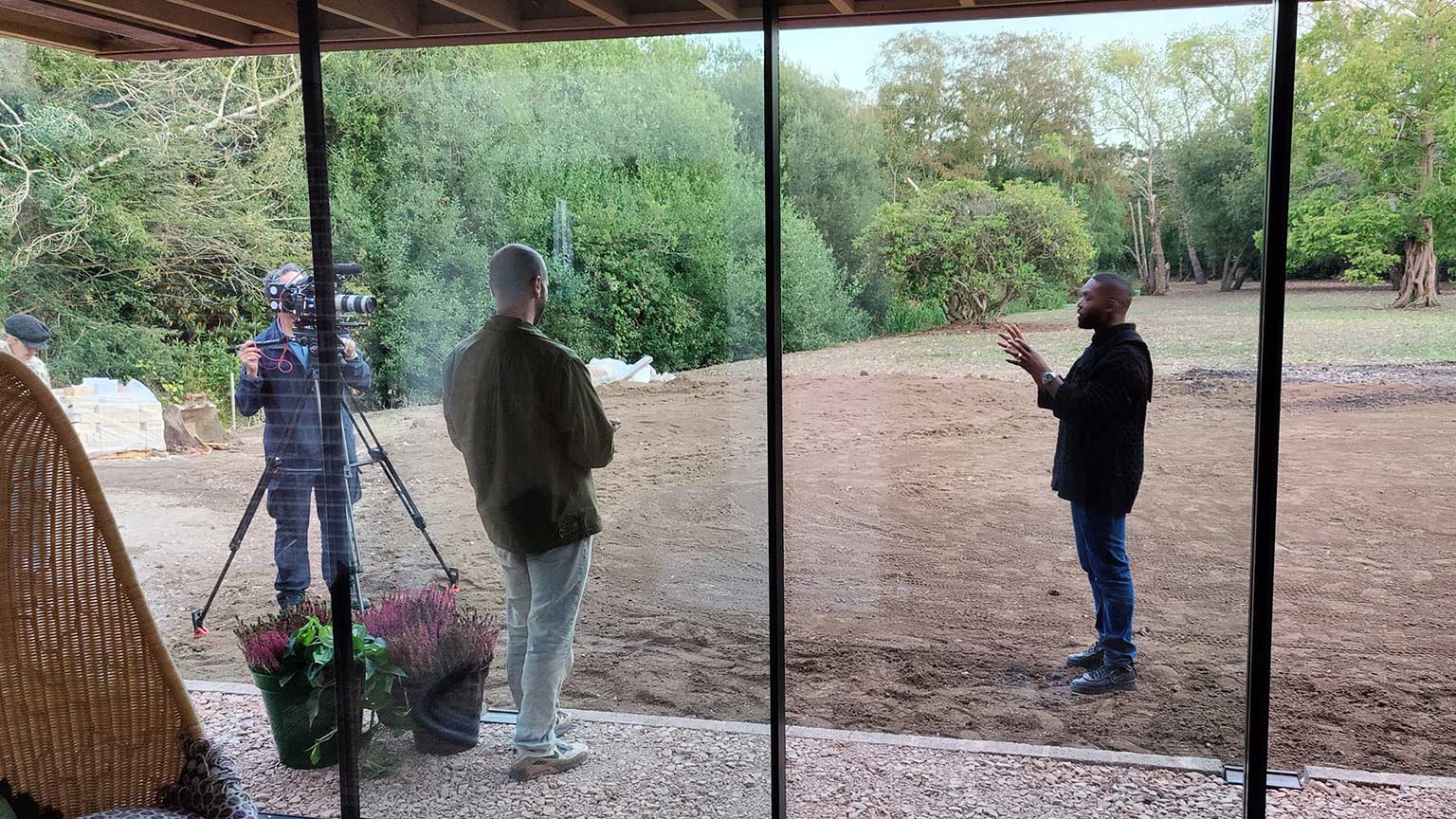 musician Tinie Tempah on site filming for tv show in front of large glass windows