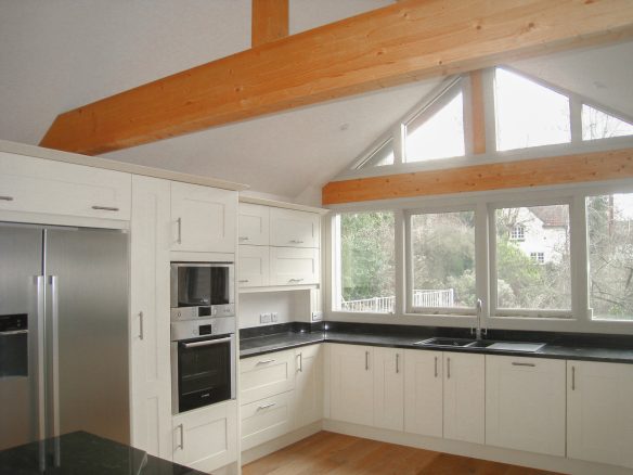 Interior of minimalistic kitchen in white tones with black surface tops