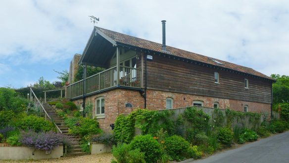 roadside view of house with steps leading up to first floor veranda