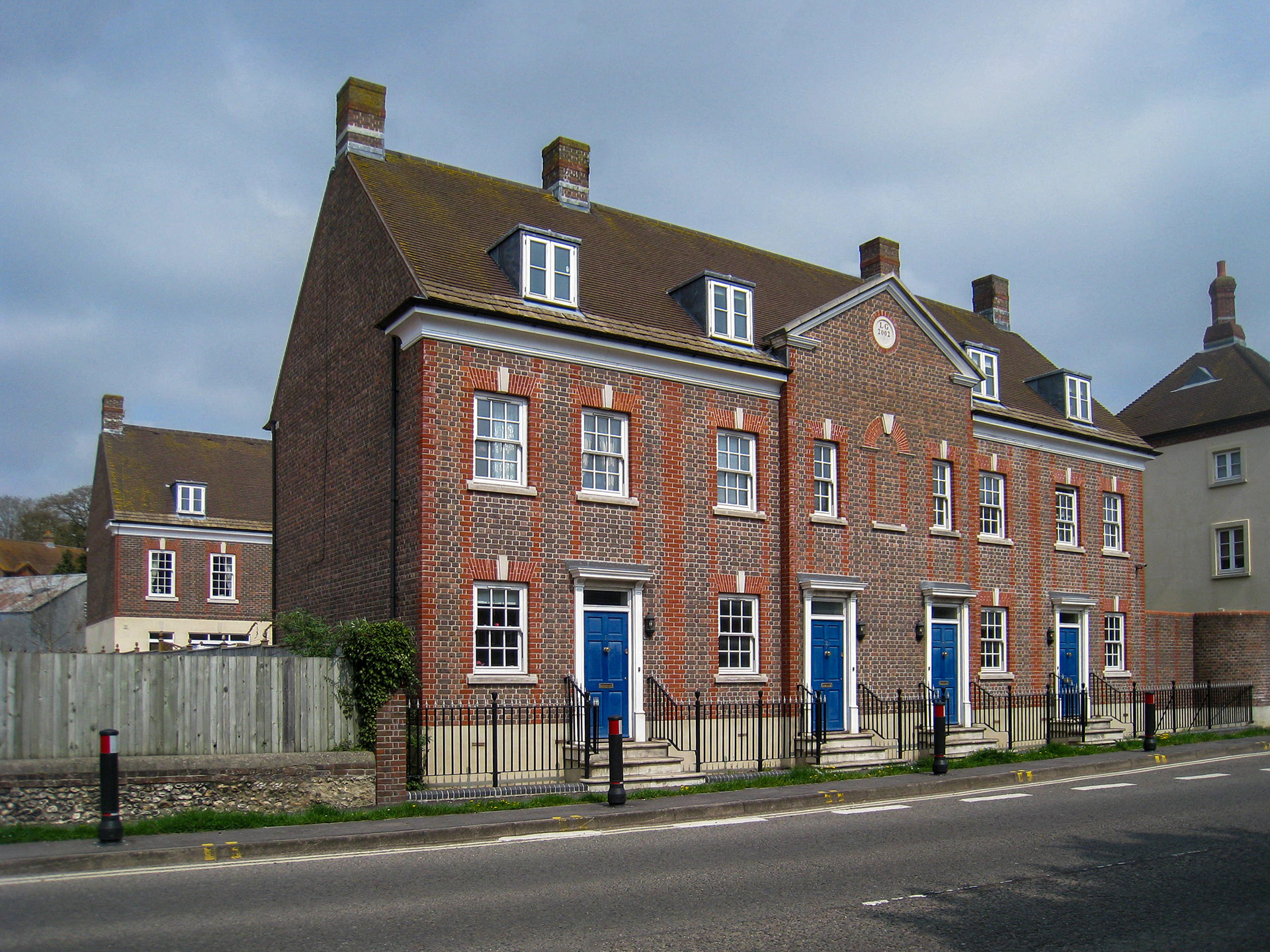 front view of terraced red brick houses from across road