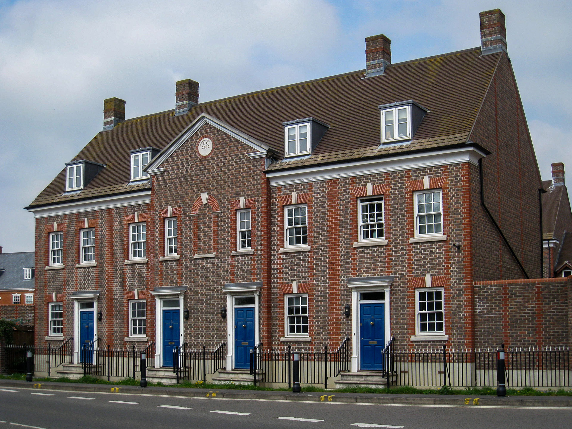 front view of terraced red brick houses from across road