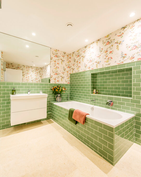 interior green bathroom with bath, sink and floral wallpaper