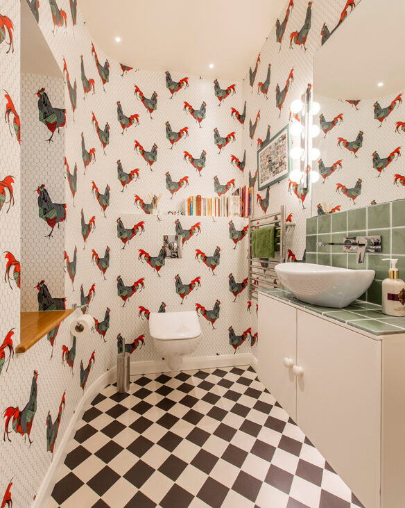 interior bathroom with funky cockerel wallpaper and back and white fall tiles