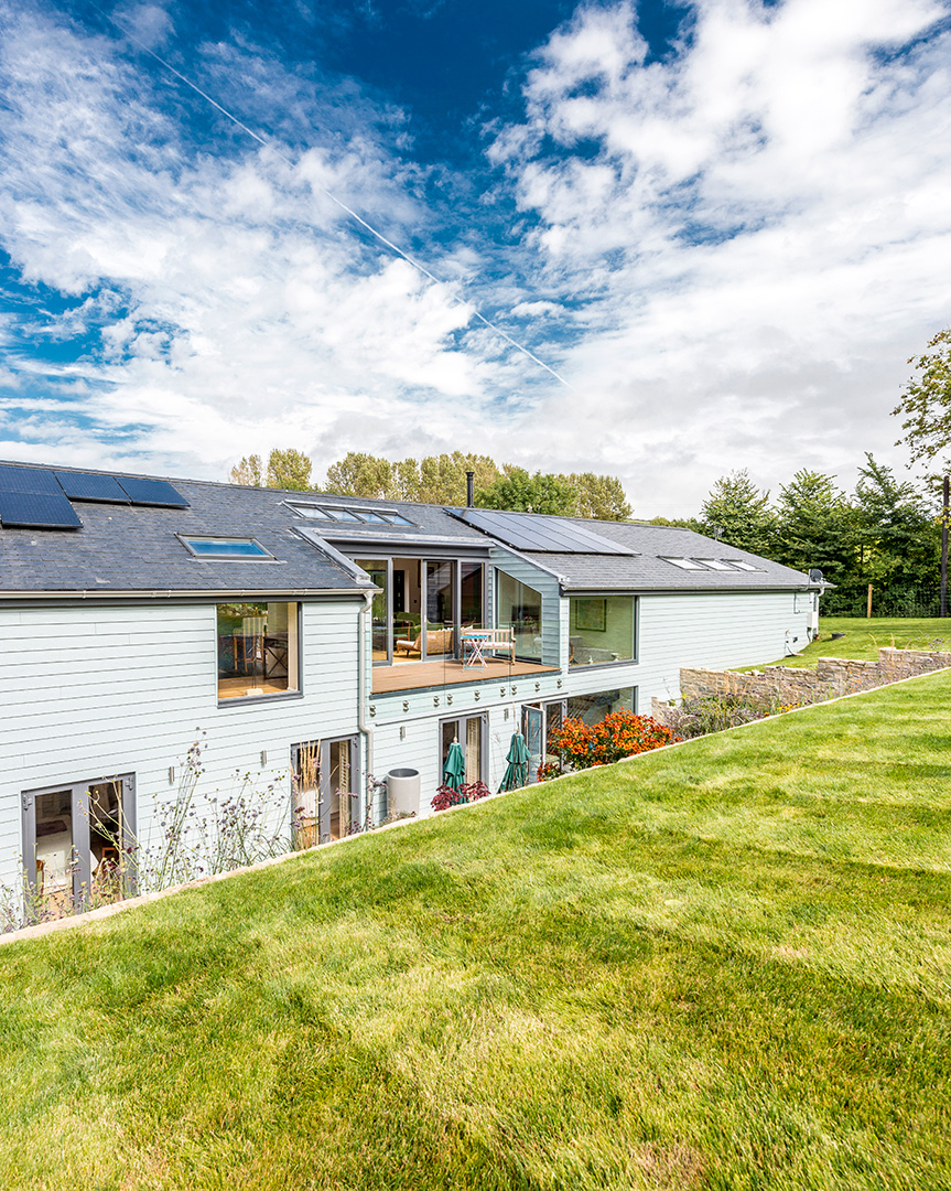 rear garden view of single storey house above ground with an extensive sunken terrace and subterranean level