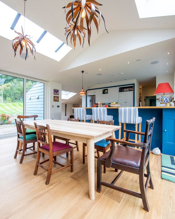 open plan kitchen living room area with blue cabinet doors and unique light fittings