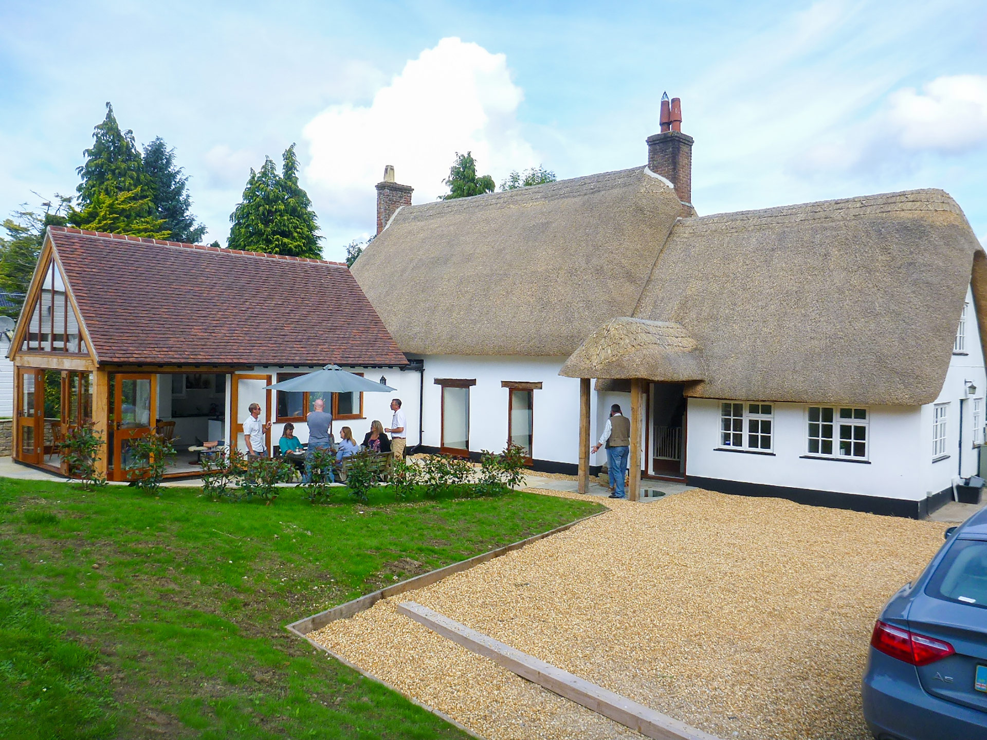 lovely thatched white house with red tiled roof extension
