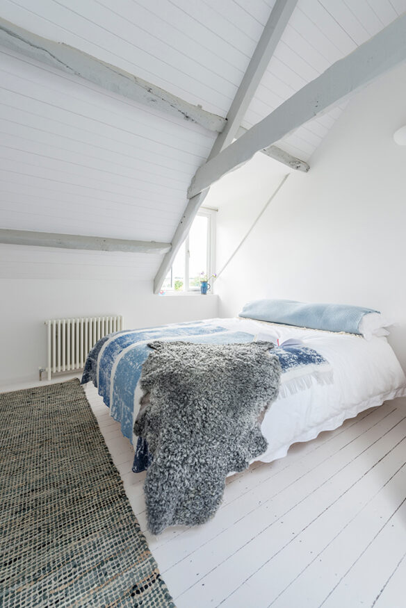 Scandi-style bedroom in eaves with exposed beams