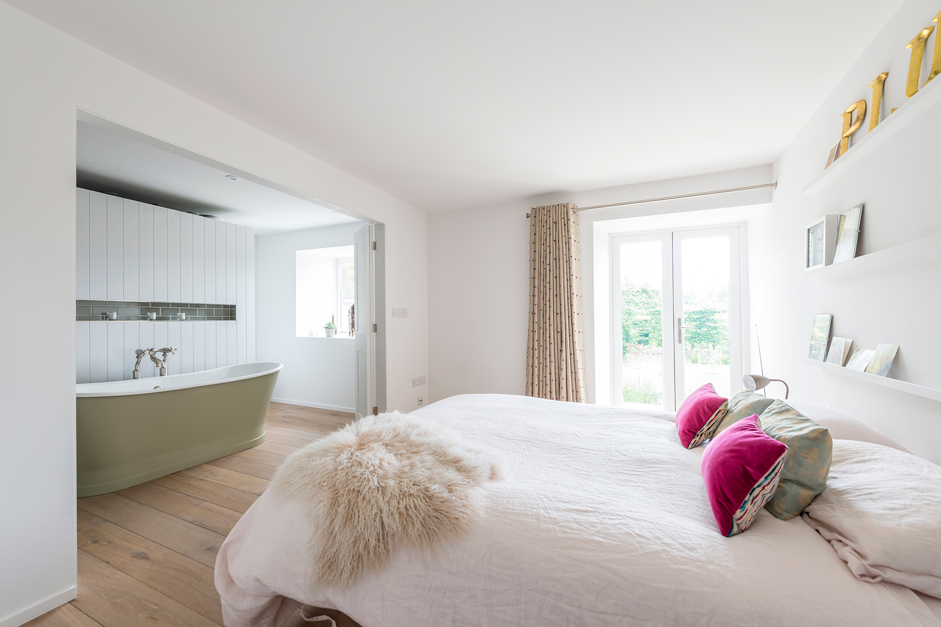 ground floor bedroom with open plan en-suite and free-standing green bath
