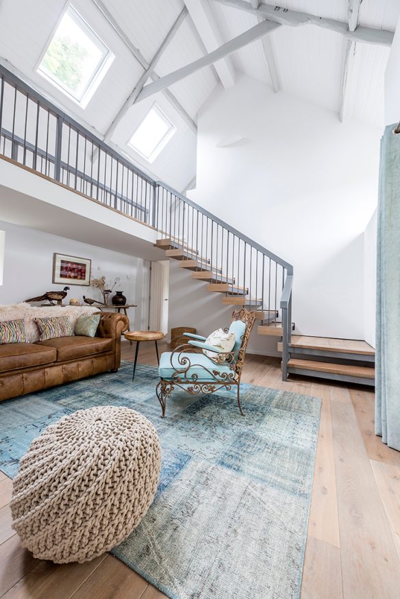 double height space living room with exposed wooden painted white beams