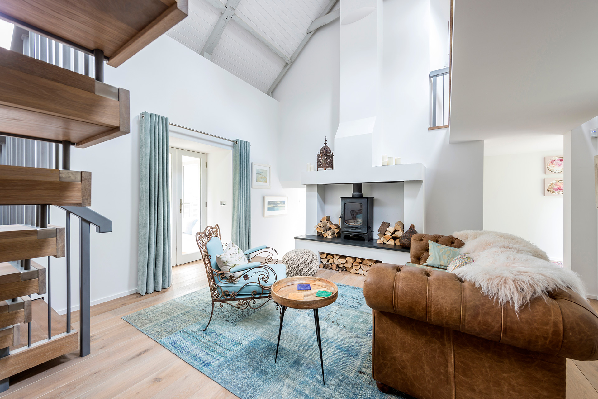 double height living area with log burner and floating staircase