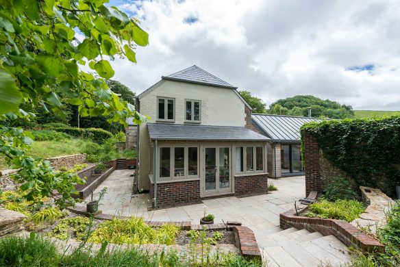 side view of house with extension leading to patio