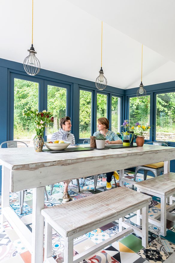 two ladies smiling sitting at table in dining area extension